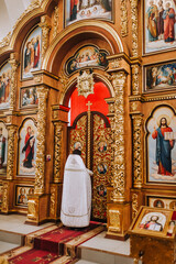 The priest, the pastor conducts a service, a ceremony near the iconostasis with the image of Jesus...