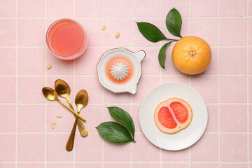 Composition with ripe grapefruit, glass of juice and plant leaves on color tile background
