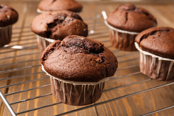 grid with tasty chocolate cupcakes on wooden background, closeup