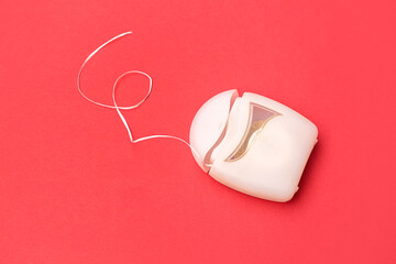 Dental floss on red background