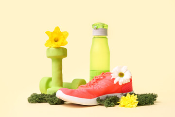 Sports equipment with spring flowers and moss on beige background