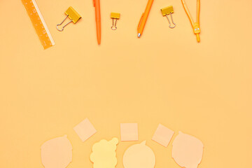 Frame made of sticky notes, pens and ruler on yellow background