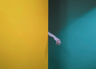 Persons left hand on yellow textile