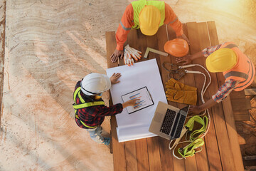 Engineers in bump caps discussing plan on construction site