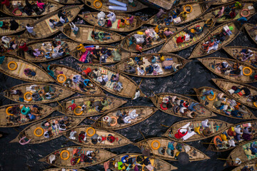 Top view of boats filled with travelers crossing the river to their workplace