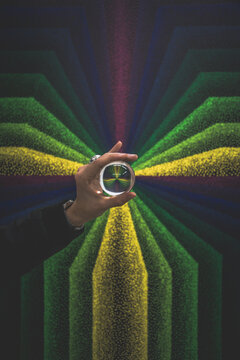 Person holding a glass ball with red and blue and green rays emitting