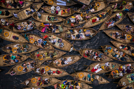 Top view of boats filled with travelers crossing the river to their workplace