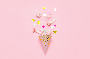 Composition with party hat, whistles and confetti on pink background