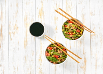 Fragrant spicy Chinese food minced ground pork belly stir fried with pickled yard long beans and red chili peppers on a wooden table, top view.