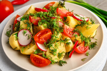 Plate of tasty Potato Salad with vegetables on table, closeup
