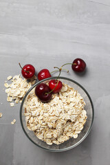 oatmeal oatmeal porridge in a glass plate bowl bowl with cherry berries on a gray background with space for text and copyspace. healthy dietary food