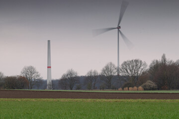 windpark in the field and forest in the morning. windturbine under construction. foggy and cloudy...