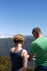 Married couple looking at the map with confussion with Madeira mountains in the background