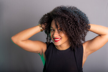 Portrait of beautiful young brunette woman messing with her hair. Dressed in black.