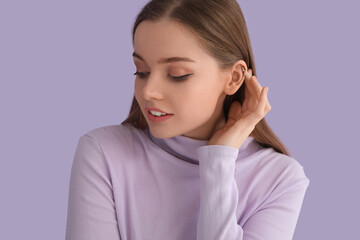 Young woman in sweater touching hair on lilac background, closeup
