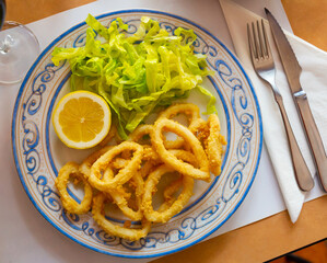 Fried calamari in a batter of tempera flour and fresh salad with lemon