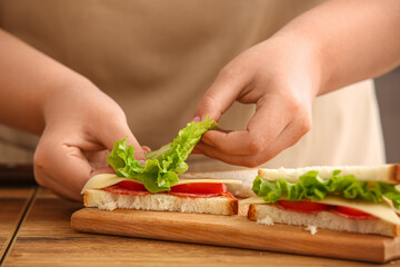 Woman preparing delicious sandwiches, closeup