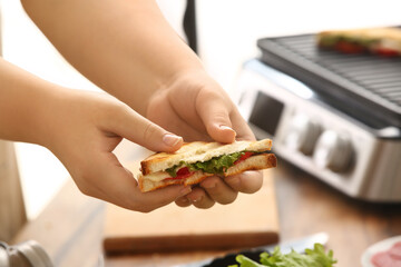 Woman holding delicious grilled sandwich, closeup