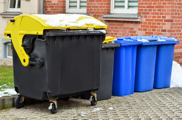 View of garbage containers in city on winter day