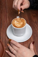 Manos revolviendo una taza de cafe