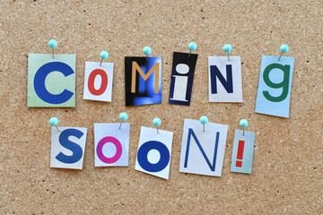 Coming Soon! notice pinned on bulletin board using cut out letters from a magazine 