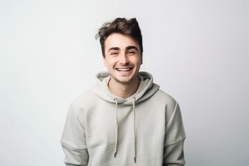 Obraz premium Young man with a cheerful smile wearing a sweatshirt stands alone on a white background, looking at the camera. Generative ai.