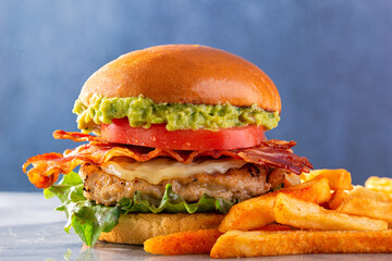 Turkey Bacon Burger with French Fries on a Dark Blue background; copy space