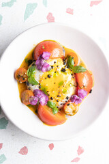 Ensalada de tomate albaca y burrata en plato redondo liso