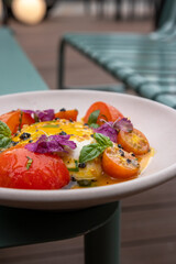 Ensalada de tomate albaca y burrata en plato redondo liso