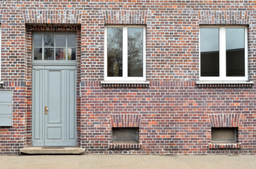 Fototapeta na wymiar View of brick building with grey door and windows