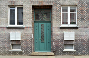 Fototapeta na wymiar View of brick building with green door and windows