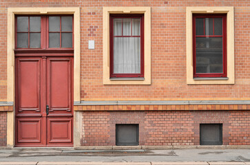 Fototapeta na wymiar View of brick building with red door and windows