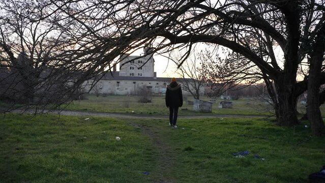 Slender man approaching a scary abandoned building