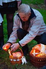 Elderly man lighting a candle in an Easter basket