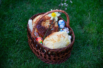 Easter basket with holiday food on the grass
