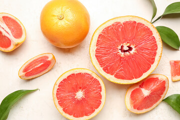 Composition with juicy grapefruit pieces and plant leaves on light background