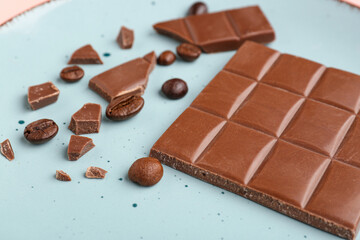 Plate with pieces of tasty chocolate and coffee beans, closeup