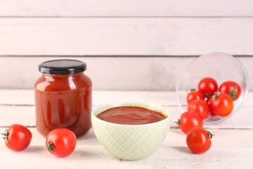 Bowl of tasty tomato paste on white wooden background