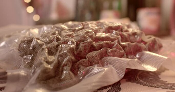 Close-up of cannabis packaging on the table. Tight plastic vacuum. Ready for transport in an odorless public place. Soft focus.