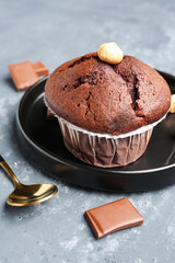 Plate with tasty chocolate cupcakes on blue background