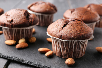 Board with tasty chocolate cupcakes on dark wooden background, closeup