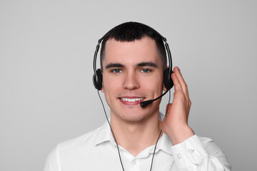 Hotline operator with headset on light grey background