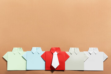 Many paper shirts on brown background, flat lay with space for text. Recruiter searching employee