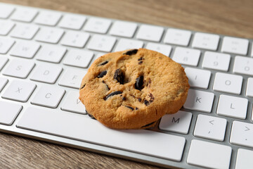 Chocolate chip cookie on keyboard, closeup view