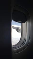 Janela de avião mostrando a turbina e céu azul