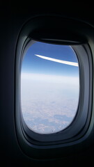 Janela de avião mostrando horizonte azul.