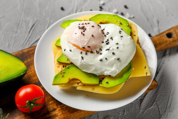 Plate with tasty egg Benedict on grey background, closeup