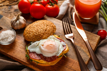 Wooden board with tasty egg Benedict on table