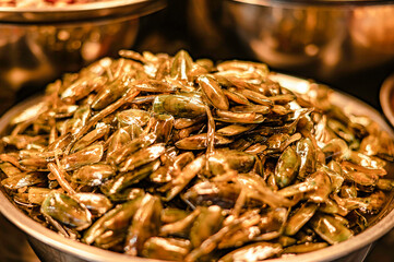 Mussels pickled in fish sauce, put in a container for sale at Nong Mon Market, Bang Saen, Thailand.