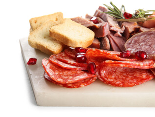 Board with assortment of tasty deli meats isolated on white background, closeup